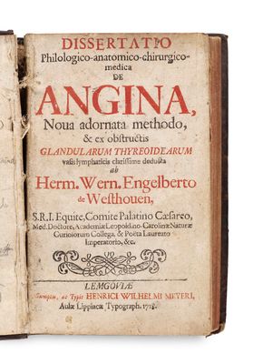 un vieux livre sur lequel on peut lire des mots, ouvert sur une surface blanche