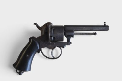 a close up of a revolver on a white surface
