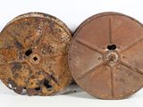 two old rusty reels sitting next to each other on a white surface