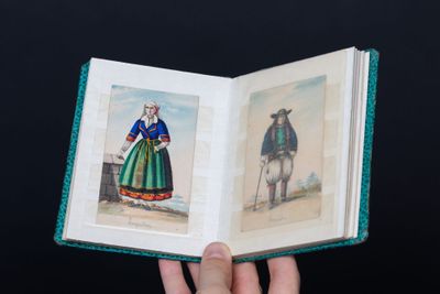 a person holding an open book with pictures of people on it