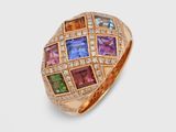 gros plan d'une bague en or avec des pierres multicolores