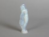 a figurine of a woman standing on a gray surface