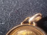a close up of a gold colored watch on a black surface