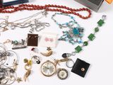 a lot of jewelry on a table with a watch