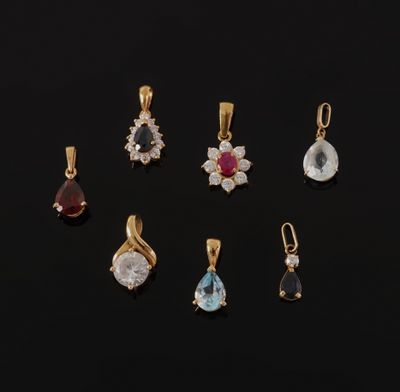 a set of seven gold and gems pendants on a black background