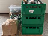une caisse verte posée sur une palette, à côté d'une pile de cartons