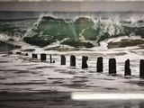 une photo d'une photo représentant une vague qui se brise sur la plage