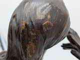 statue of a woman with long hair holding a cell phone to her ear