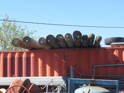 un conteneur rouge sur lequel sont empilés plusieurs fûts