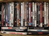 un grand nombre de DVD dans une boîte en carton posée sur le sol