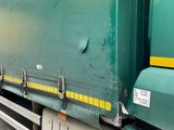 a green semi truck with a yellow star on the side