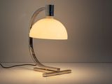 a white table lamp sitting on top of a table next to a white wall