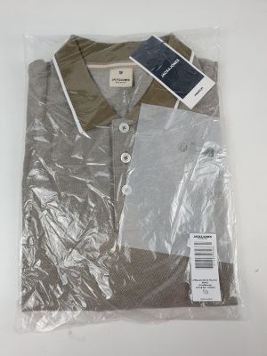 La chemise se trouve dans un sac en plastique muni d'une étiquette.