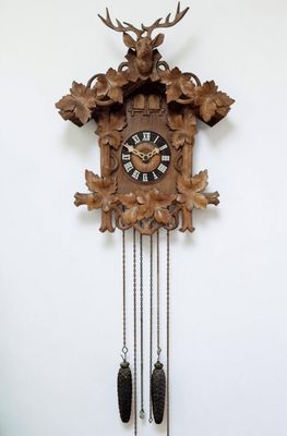 une horloge à coucou en bois ornée d'une tête de cerf