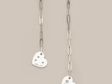 a pair of earrings with heart charms hanging from them