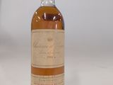 une vieille bouteille de whisky posée sur une surface blanche