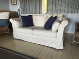 a white couch with blue pillows on it in a living room