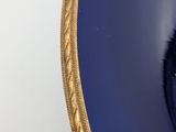 a close up of a blue plate with a gold rim