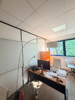 une pièce avec un bureau, une chaise et un ordinateur posé dessus