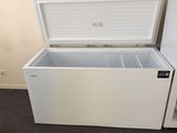 a white chest freezer sitting in the corner of a room