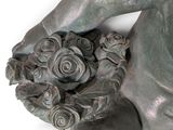 a statue of a woman holding a flower in her hands