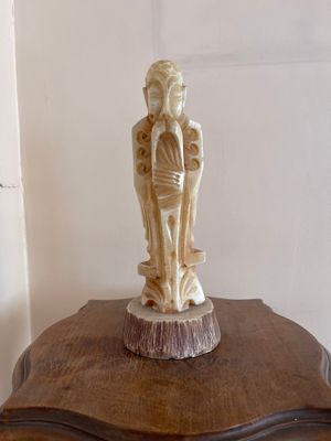 une statue représentant un homme et une femme posée sur une table en bois