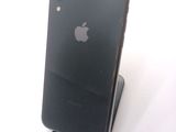 a black iphone sitting on a stand on a white surface