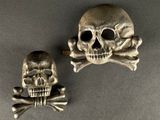 broches représentant une tête de mort et des os croisés sur un fond gris