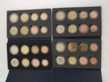 four boxes of different colored coins on a white surface