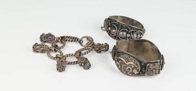 deux bijoux en argent posés sur une surface blanche