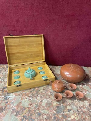 a small wooden box with a tea set in it on a table