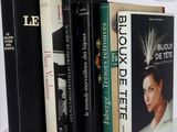 several books are lined up on a white table