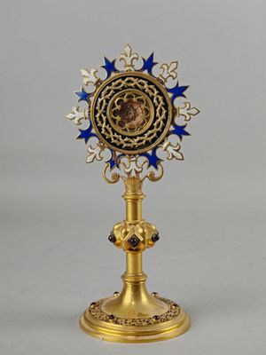 une image représentant une horloge dorée et bleue posée sur un socle