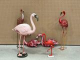 trois flamants roses qui se tiennent les uns à côté des autres
