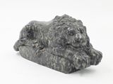 a statue of a lion that is laying on a rock