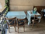 a table and chairs on a balcony with a blue and white checkered table cloth