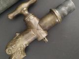 a brass faucet that is next to a knife on a table