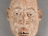 a clay mask of a man ' s face on a gray background