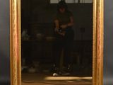 le reflet d'une femme dans un miroir accroché au mur