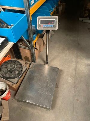 une photo d'une balance dans un entrepôt avec des cartons