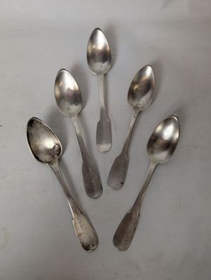 six silver spoons are arranged in a circle on a white surface
