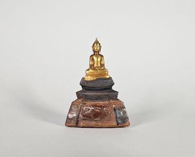 une image représentant une statue d'une personne assise sur un bloc de bois