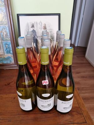 trois bouteilles de vin sont posées sur une table, à côté d'une photo encadrée