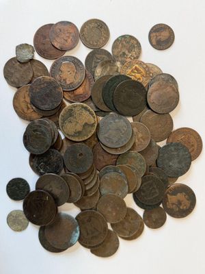 a pile of old coins on a white surface