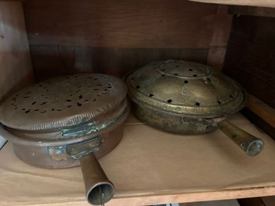 two pots and pans sitting on a shelf in a cabinet