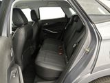 the back seats of a silver car with a black seat belt