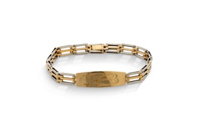 un gros plan d'un bracelet orné d'une plaque dorée sur fond blanc