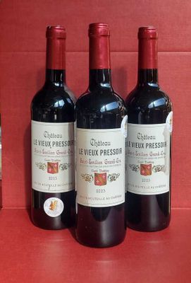 three bottles of red wine are lined up on a red counter