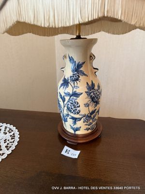 a blue and white vase sitting on a table next to a lamp