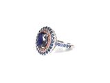 a close up of a ring on a white surface with blue and red stones